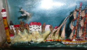 Details of ship in bottle with sailing ship, U-boat, airplane, village all visible